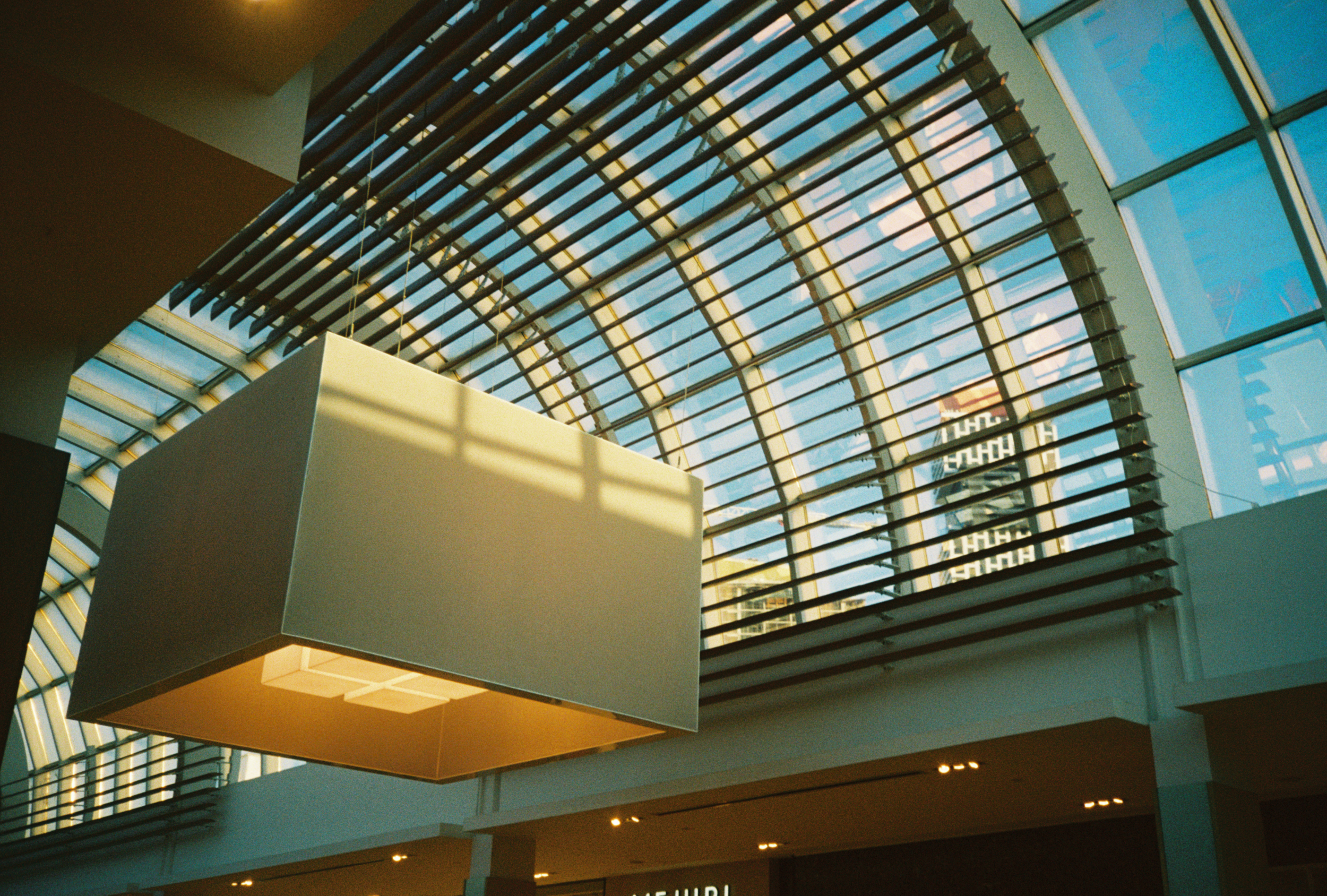 some architecture in a mall, with some neat ceiling arch in the background and a cool square lamp in the foreground