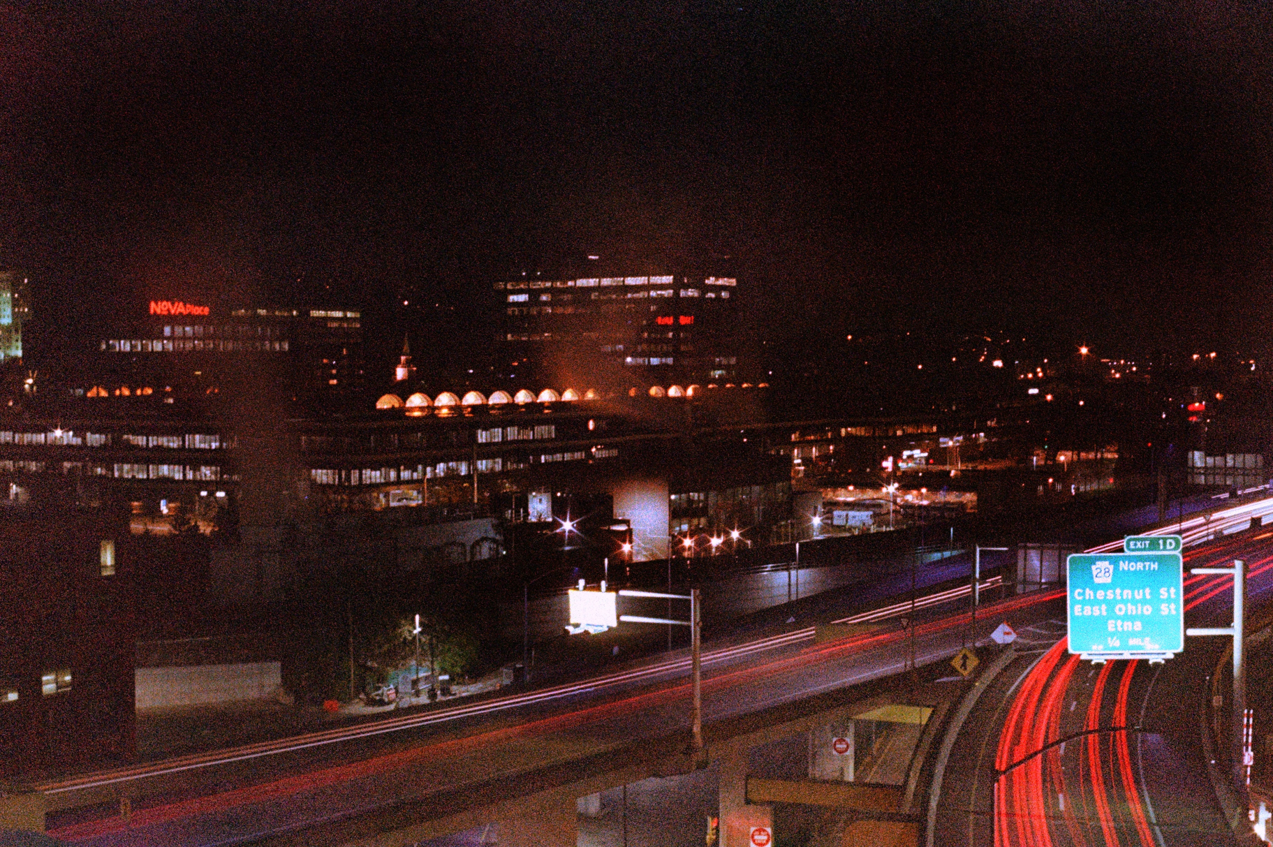 a highway overpass on grainy photo stock, with red light trails